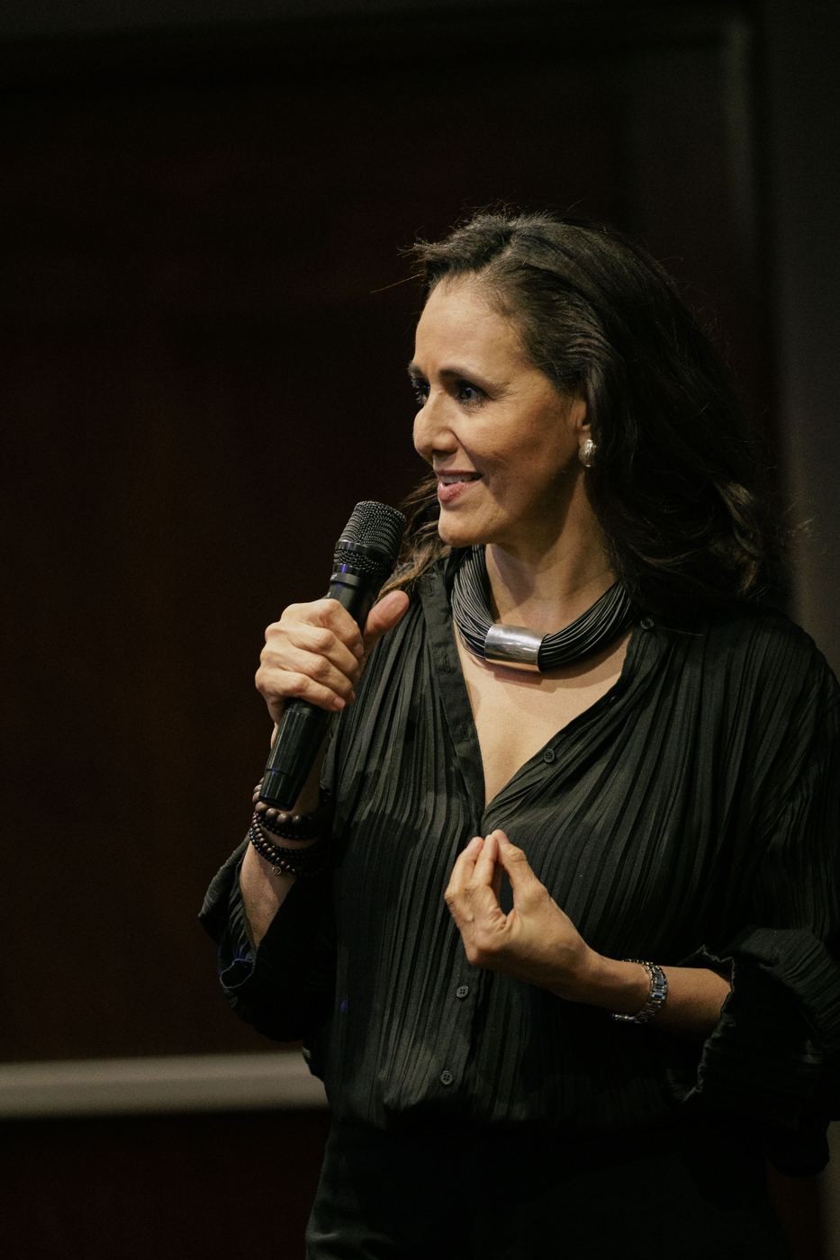 Bárbara Castro dando una conferencia con micrófono